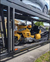 A touring motorcycle being transported in an enclosed trailer, showcasing the professional auto transport services